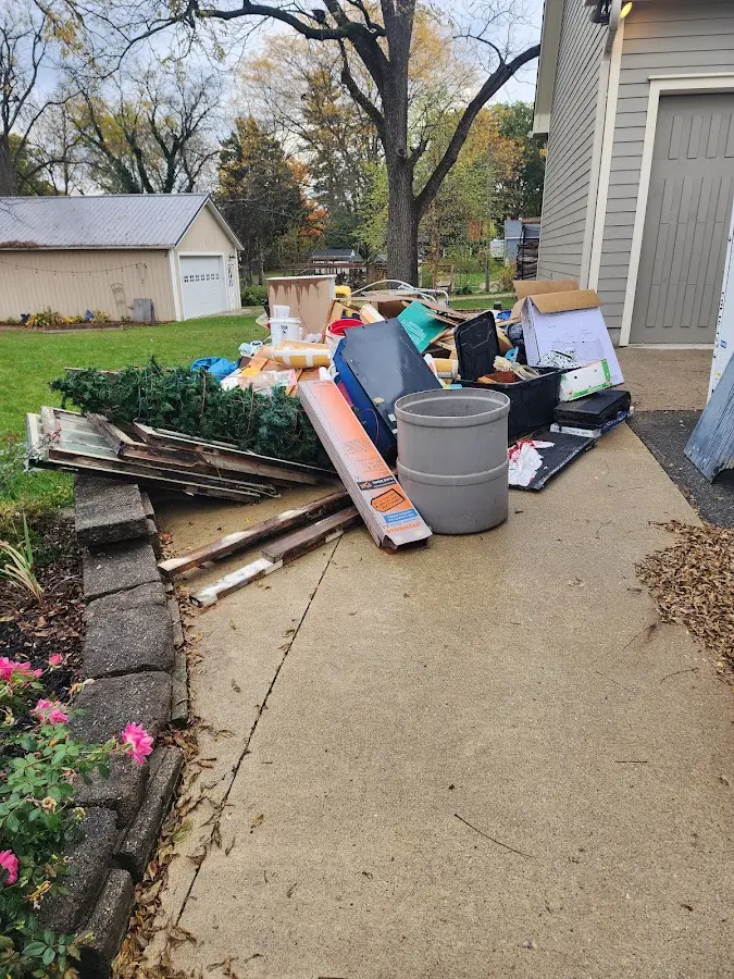 Dumpster being loaded with debris for 12 Yard Dumpster Rental in Ridgewood